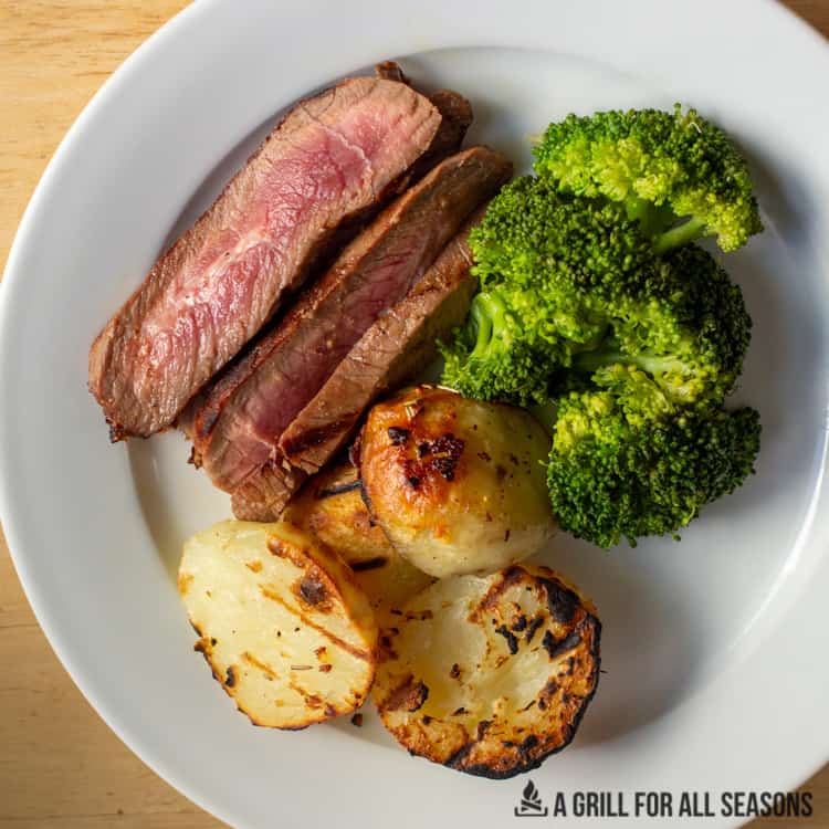 sliced steak with broccoli and potatos