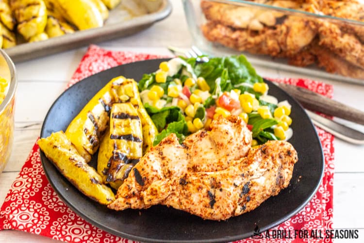 plate with tajin chicken grilled yellow squash and corn salsa salad