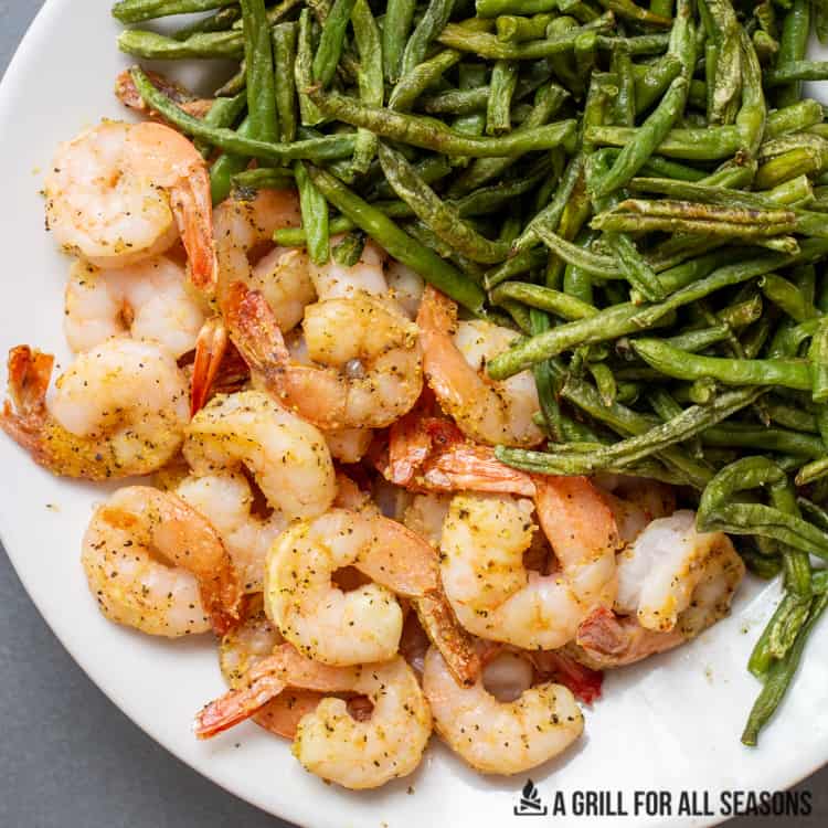 cooked prawns on a plate with green beans