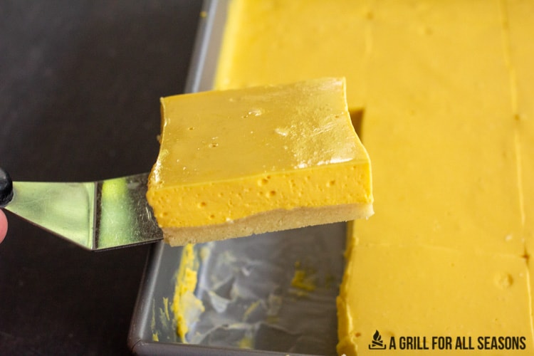 a spatula lifting up one of the one of the No Bake Mango Cheesecake Bars