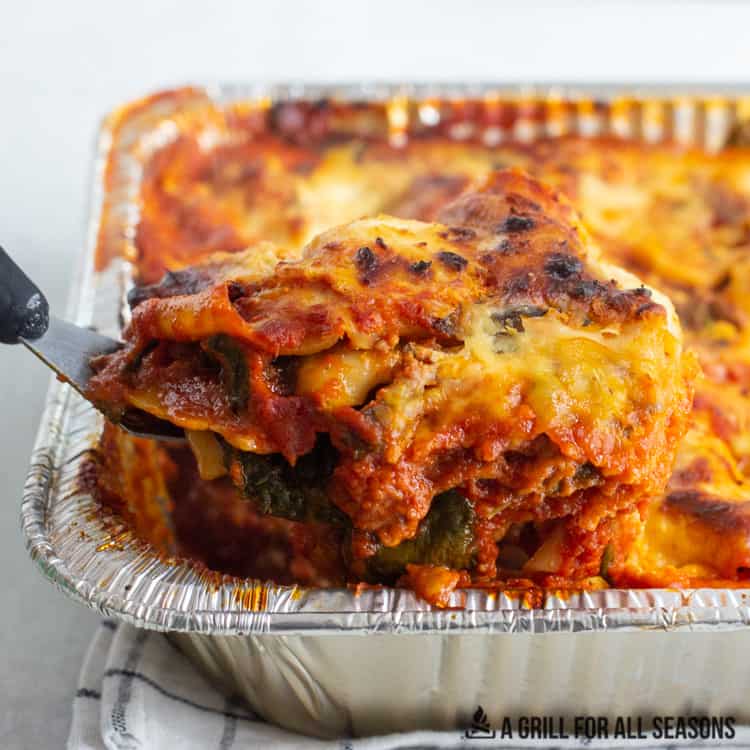 spatula lifting slice of lasagna from tray