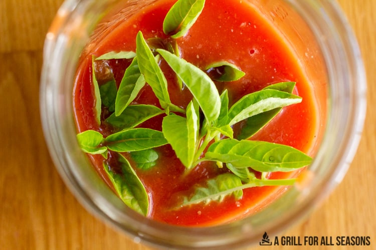 Jar of smoked tomato sauce with fresh basil.