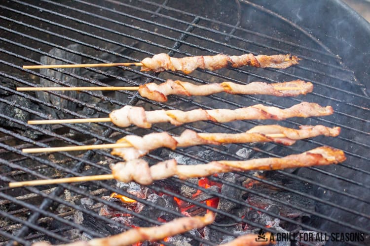Bacon skewers cooking on the grill.