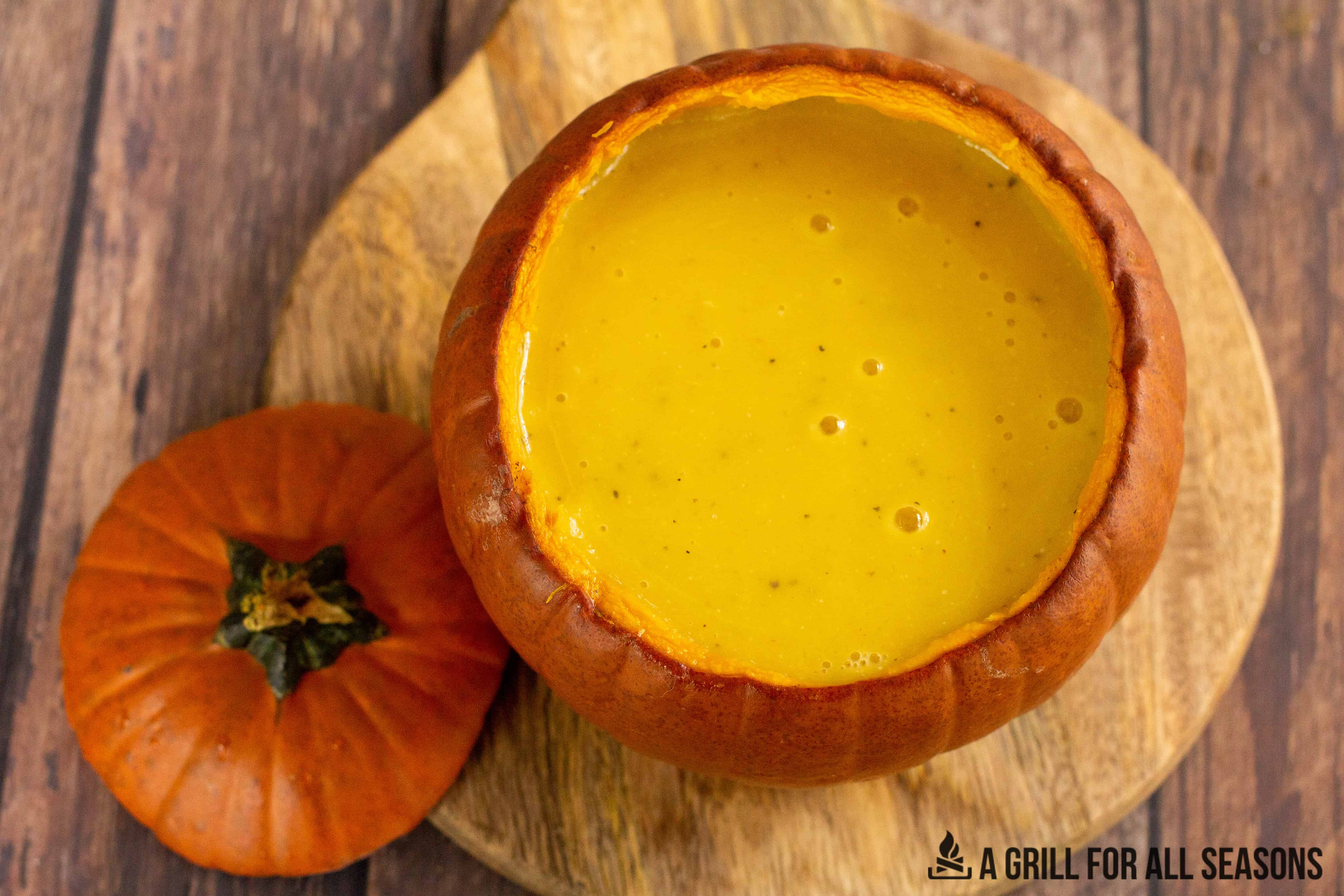 Pumpkin filled with smoked pumpkin soup with top of pumpkin lid.
