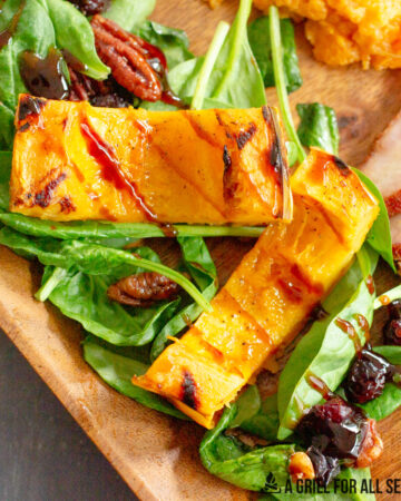grilled delicata squash sliced and served on a bed of spinach