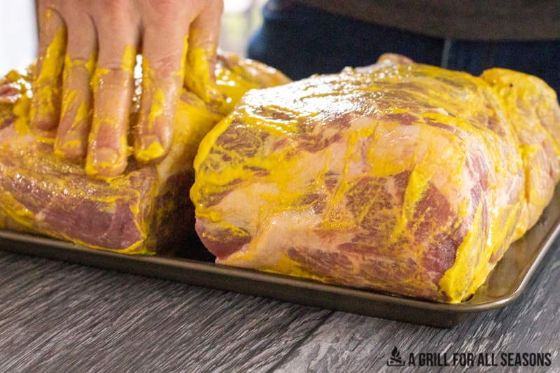 yellow mustard being applied to pork