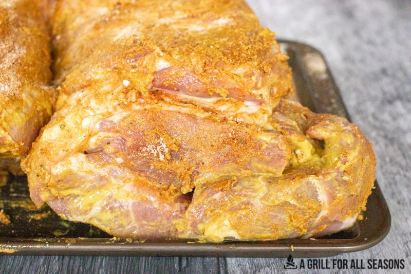 pork covered in seasoning ready for smoker