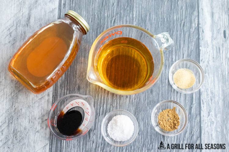 Brine ingredients of honey, ginger, garlic, balsamic vinegar, salt, and apple juice in ramekins and measuring cups.