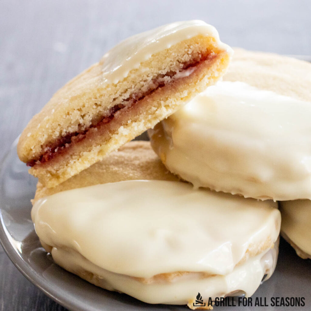 one of the raspberry white chocolate cookies cut in half and resting on a plate