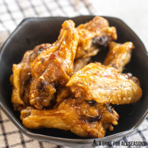 air fryer frozen wings cooked until crisp in bowl with sauce