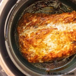 browned pork roast in air fryer basket
