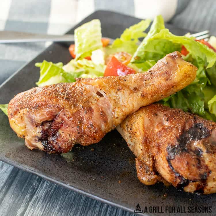 smoked chicken legs on plate with salad