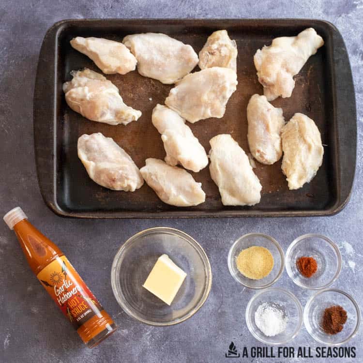 wings on baking stone next to butter and seasonings