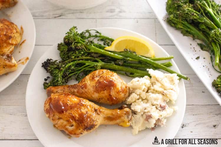overhead shot of air fryer bbq chicken on a plate with grilled broccolini and boursin mashed potatoes