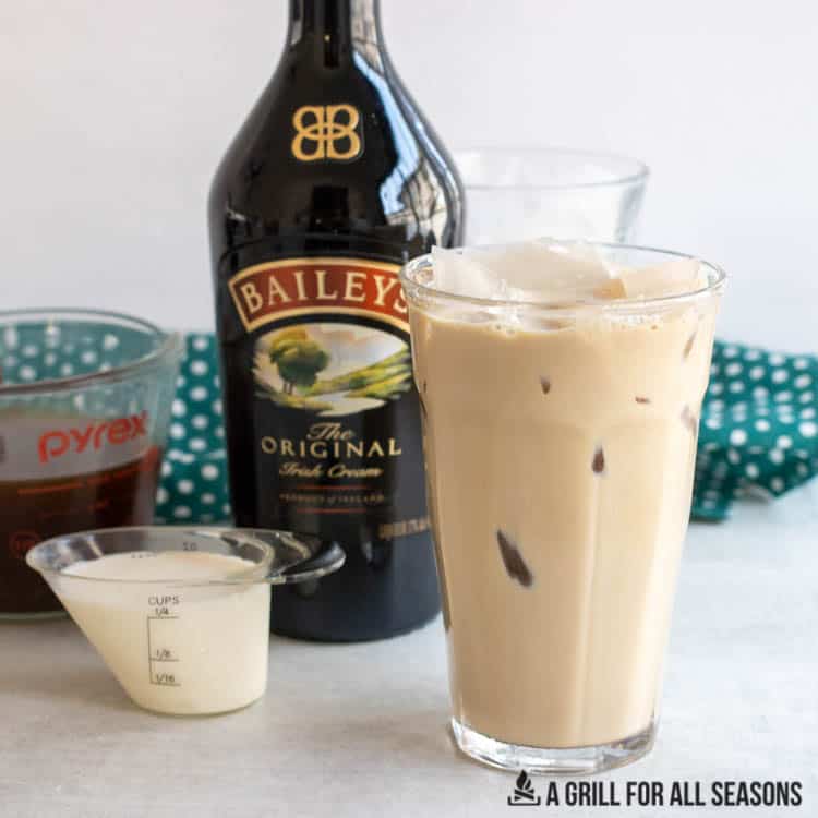 glass of baileys iced coffee with a bottle of irish cream behind
