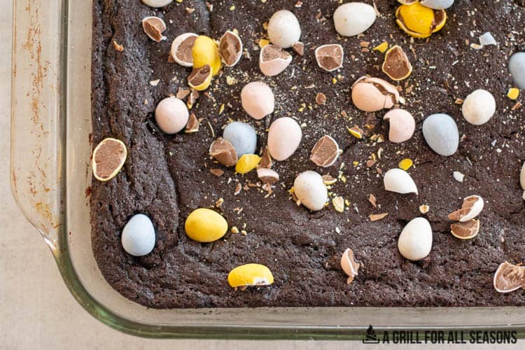 baked mini egg brownies in pan topped with chopped mini eggs