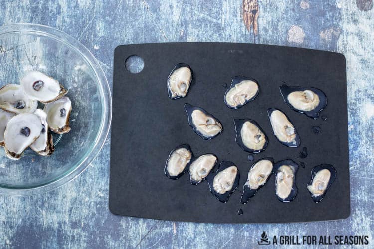 shells in bowl and oysters on cutting board