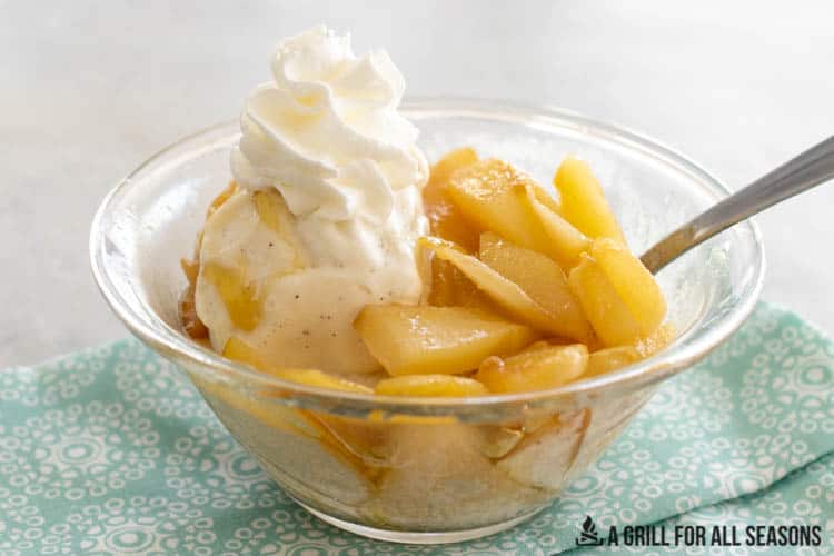 bowl of stewed pears with ice cream, honey, and whipped cream