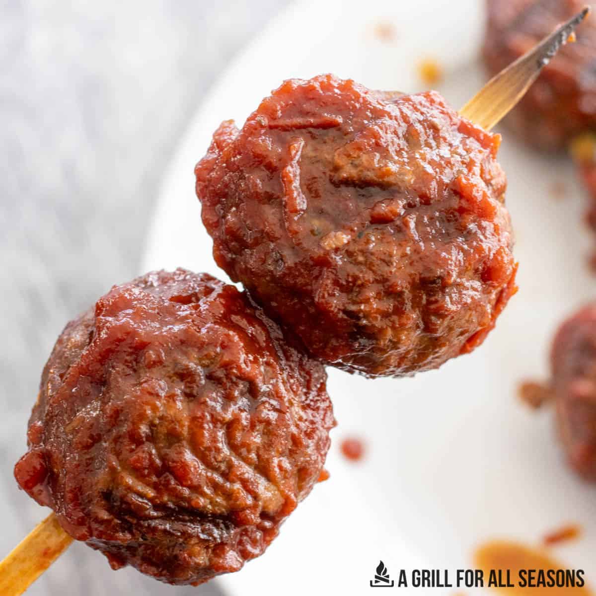 close up of two bison meatballs on skewer