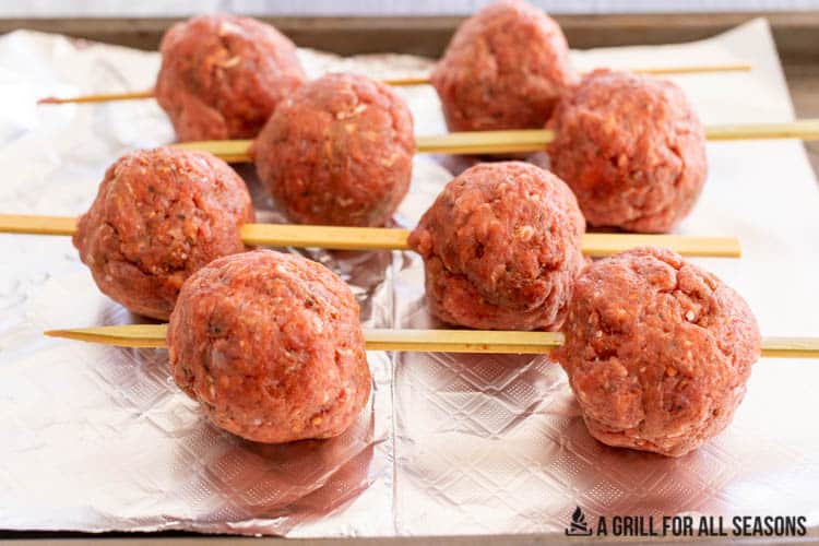 skewers with balls of meat on foil lined tray