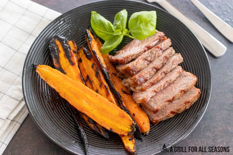 glazed carrots on a plate with steak