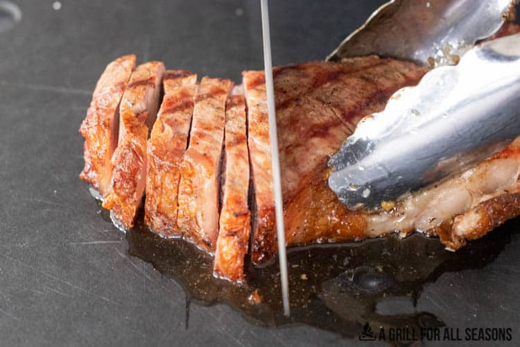 knife slicing pellet grilled steak