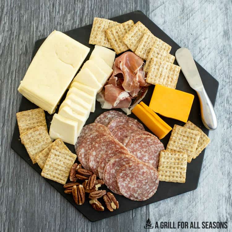 cold smoked cheeses on charcuterie board with crackers and meat