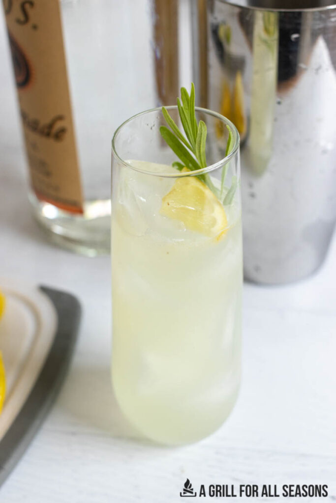 lavender lemonade cocktail in front of cocktail shaker and vodka bottle