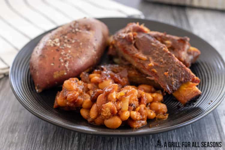 plate with ribs, sweet potato, and smoked baked beans