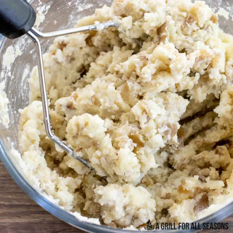 smoked mashed potatoes in bowl with masher