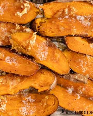 close up of halved smoked sweet potatoes topped with butter and brown sugar