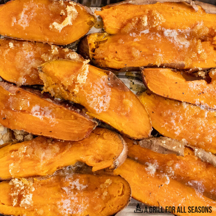 close up of halved smoked sweet potatoes topped with butter and brown sugar