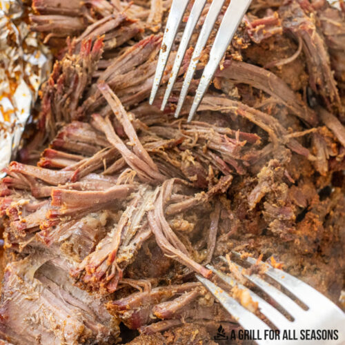 Smoked Pulled Beef close up with two forks for shredding