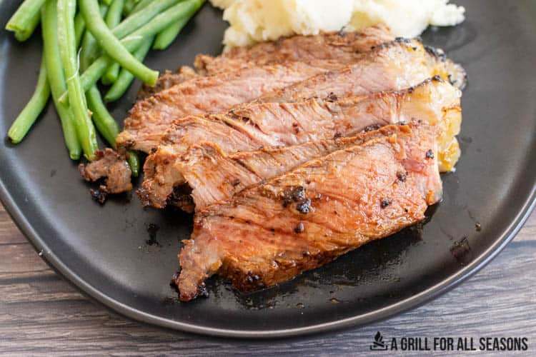 sliced smoked ribeye steak on a plate