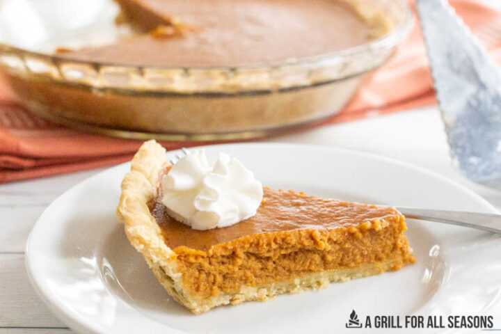 slice of smoked pumpkin pie on plate with whipped cream