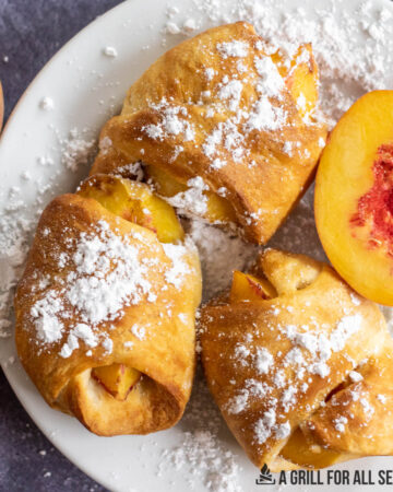 air fryer peaches with powdered sugar on plate close up