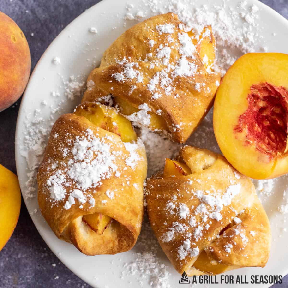 air fryer peaches with powdered sugar on plate close up