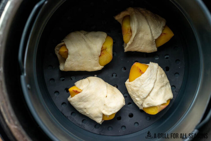 peaches wrapped in crescent dough in air fryer basket