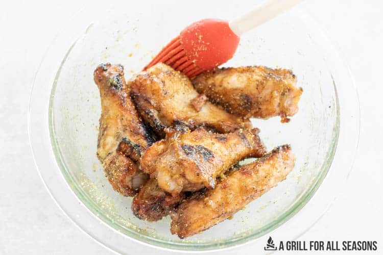 hot honey lemon pepper wings in a glass bowl being mixed