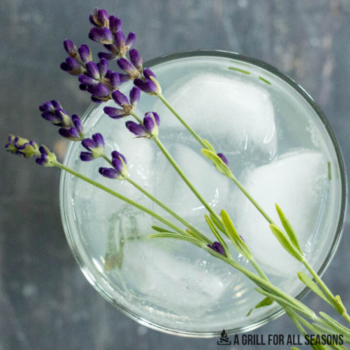 lavender resting across a glass of lemonade cocktail