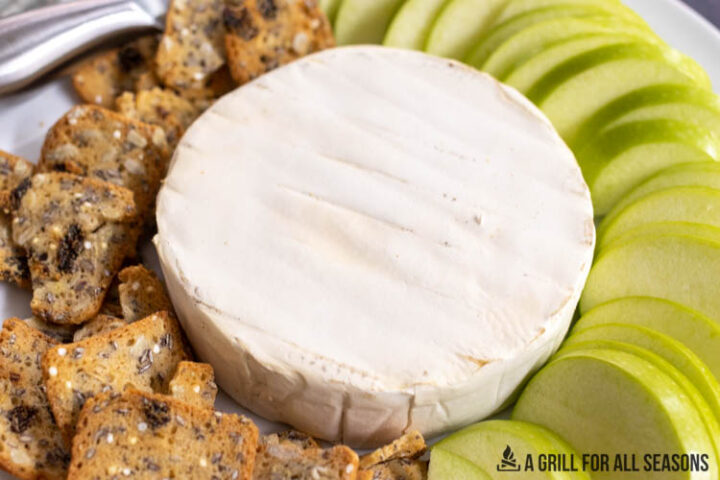 smoked brie next to granny smith apple slices and crackers