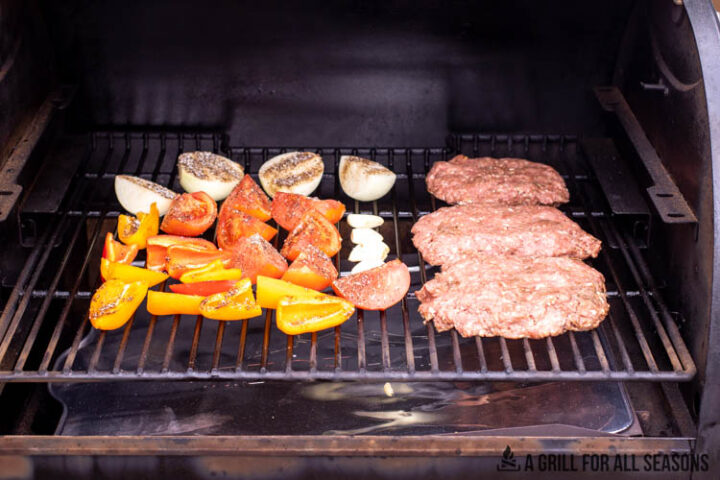ground beef and vegetables on the smoker grate