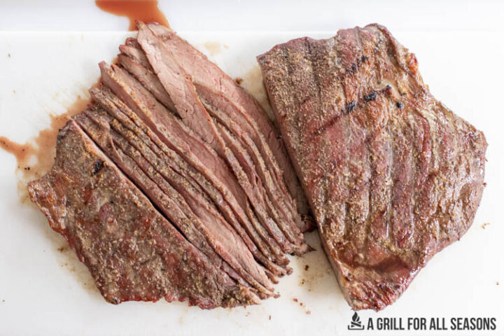 smoked flank steak sliced on cutting board