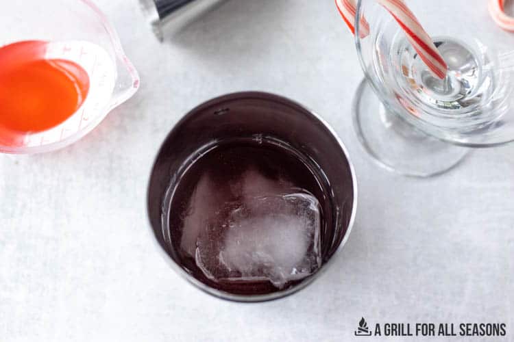 cocktail shaker with ice cubes and liquid