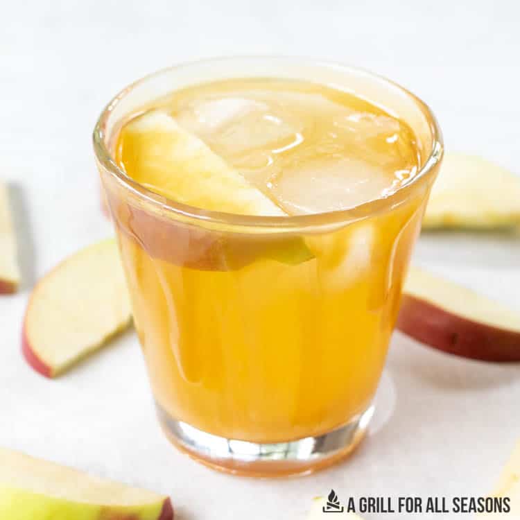 caramel vodka apple cider cocktail garnished with apple slice