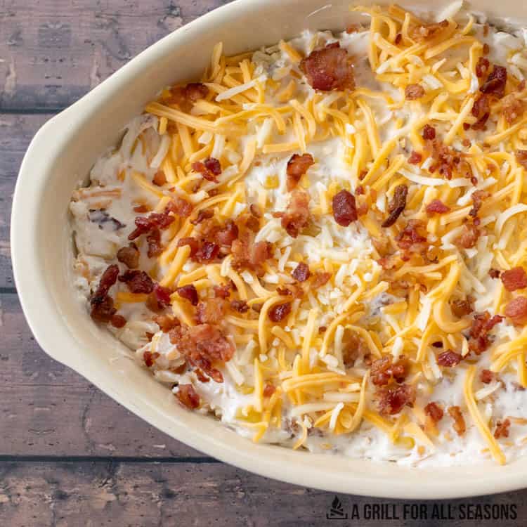 shredded cheese and bacon on top of mixture in baking dish