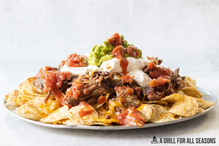 smoked nachos on platter with toppings