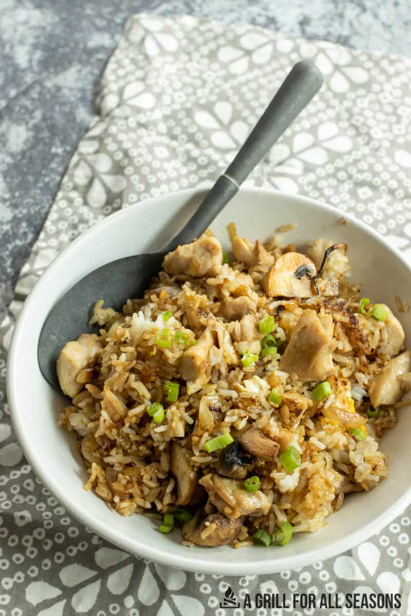 blackstone chicken fried rice in serving bowl with large spoon