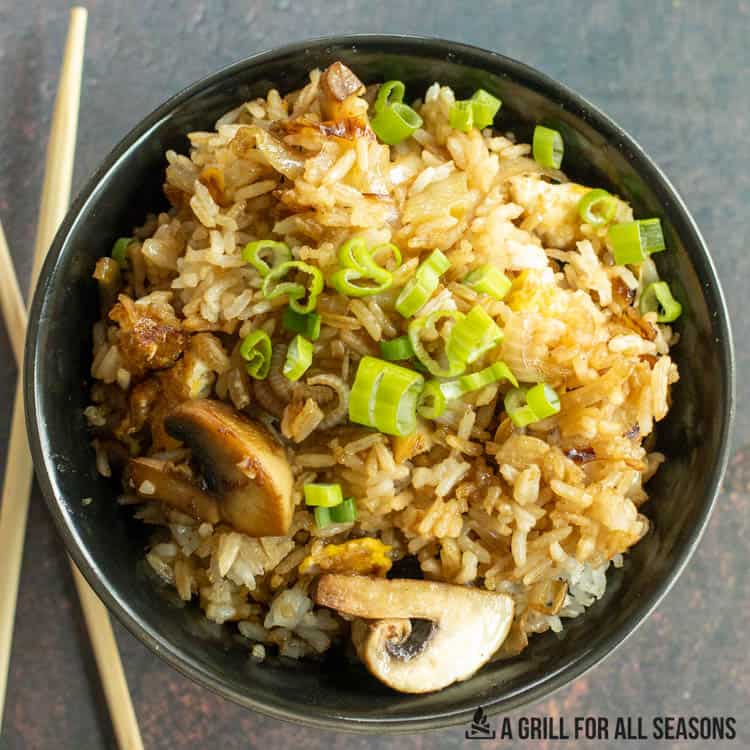 blackstone fried rice with mushrooms, and green onions in bowl
