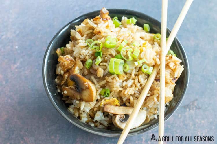 bowl full of blackstone fried rice with chopsticks resting on the bowl